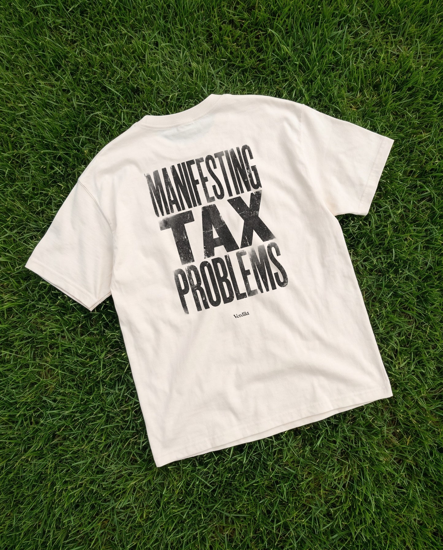 MANIFESTING TAX PROBLEMS print - tee laid on grass